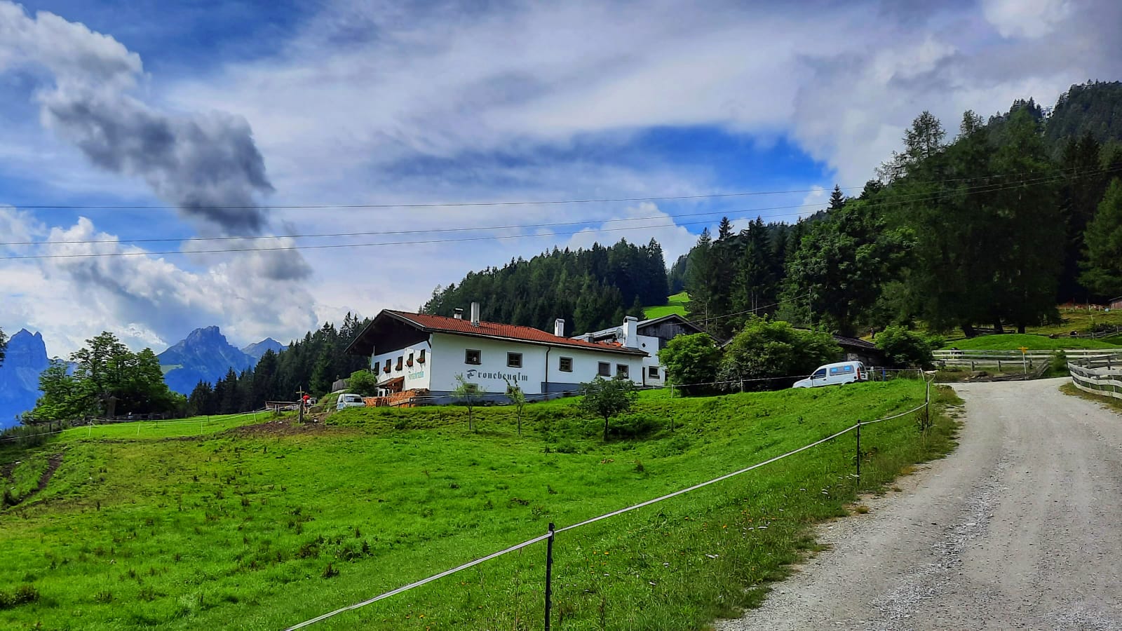Die Froneben Alm bei schönem Wetter auf einer grünen Wiese.